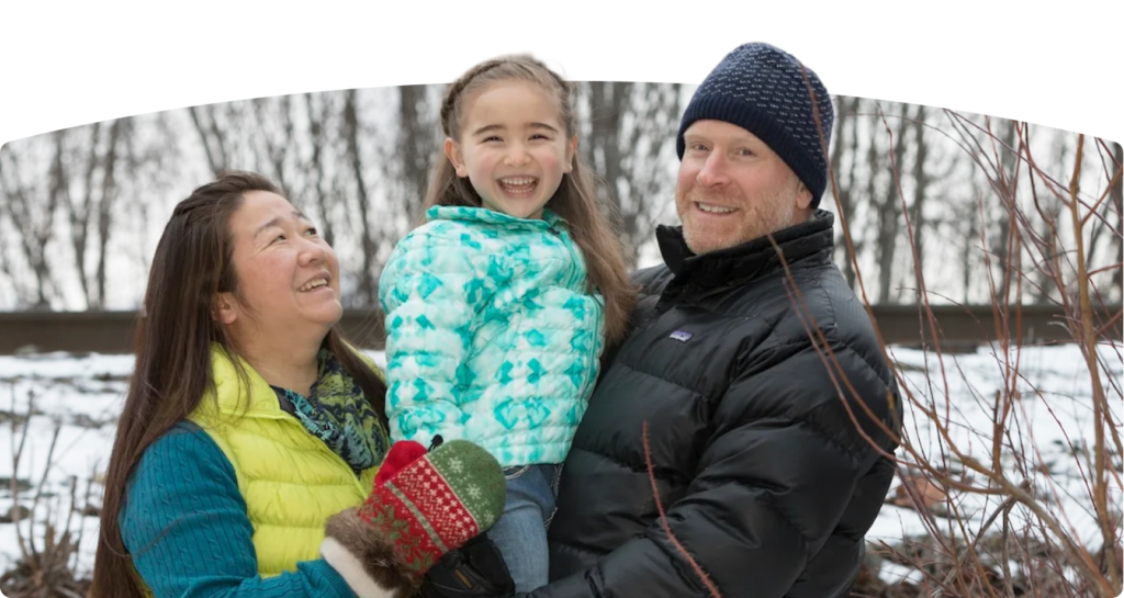 Two parents and a carried child smiling