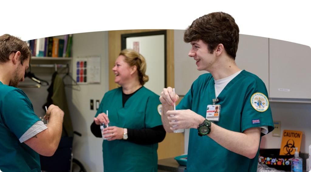 Three nurses mix a solution while training